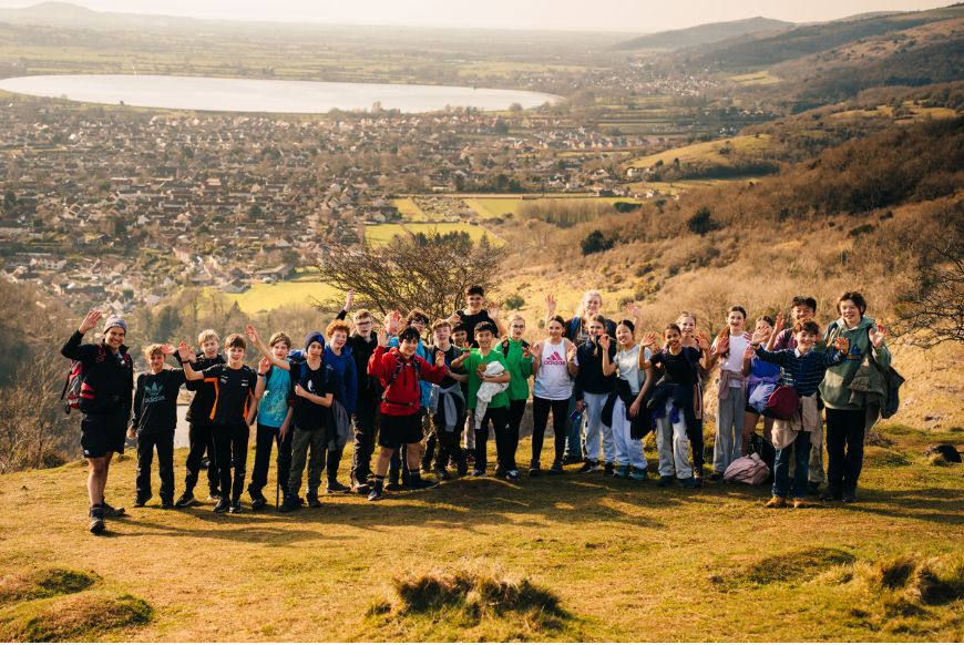 a group of scool children standing on a hill